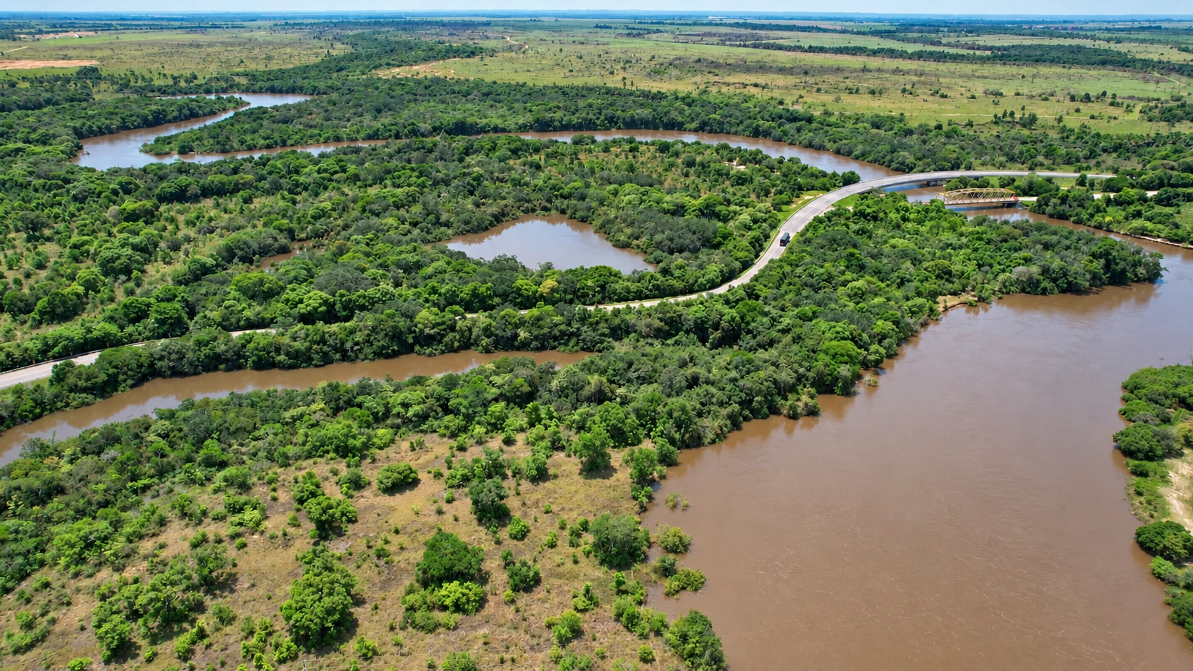 Un río rodeado de vegetación y paisaje agrícola